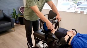 Dr. Tyler Bigenho performing a Y-strap adjustment on a patient at CleanSpine Irvine to improve spinal alignment.